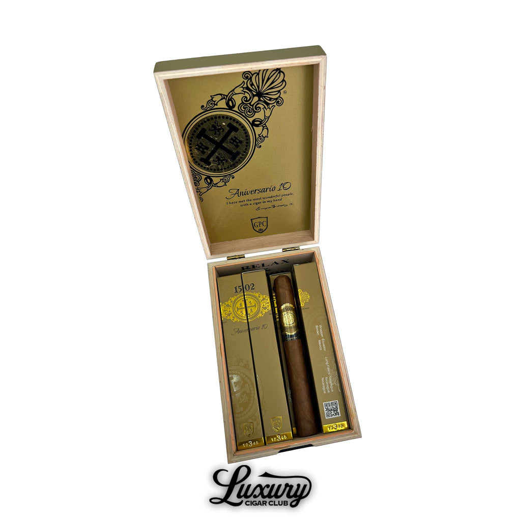 Open cedar box of 1502 Aniversario 10 Toro cigars with gold and black branding, displayed by Luxury Cigar Club.
