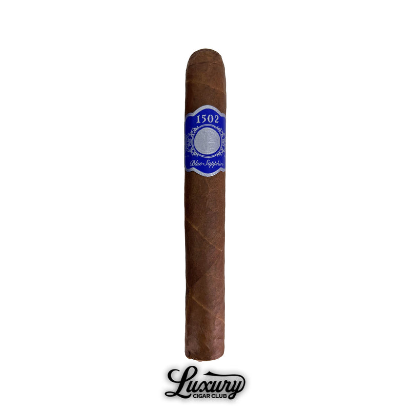 Single 1502 Blue Sapphire Toro Gordo cigar from Luxury Cigar Club standing upright with a smooth brown wrapper and blue and silver band, photographed on a white background.