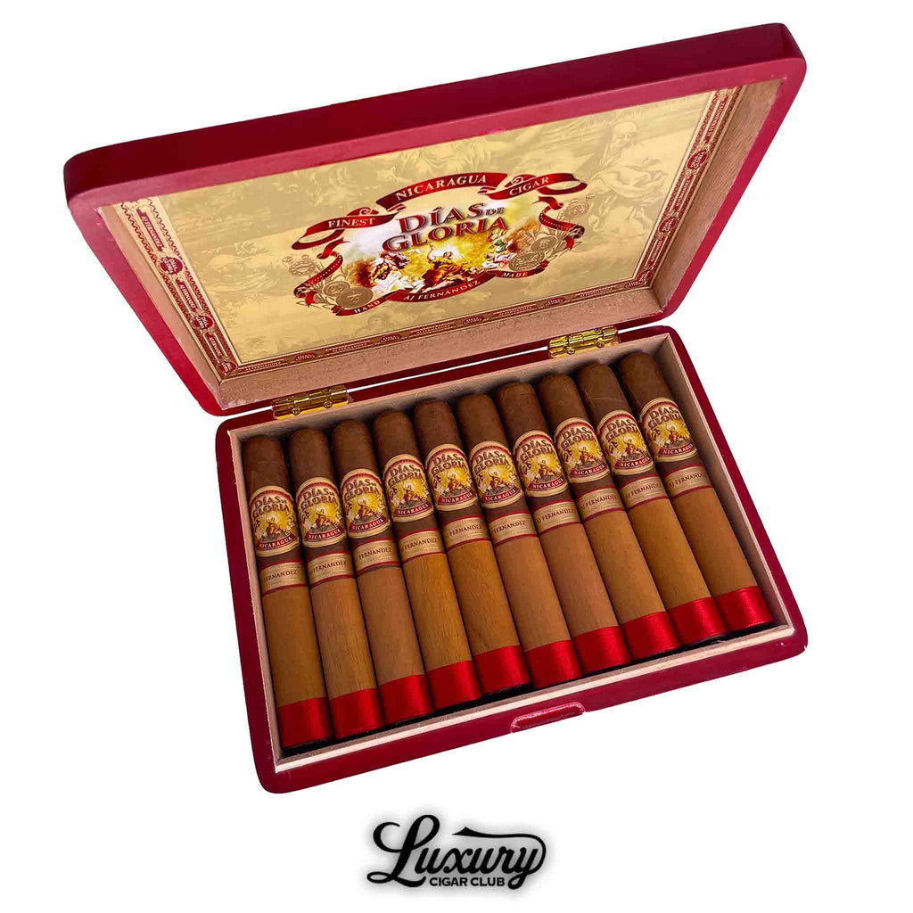 Open box of AJ Fernandez Dias De Gloria Gordo cigars featuring cedar sleeves, red ribbons, and detailed Nicaraguan branding for sale at Luxury Cigar Club.