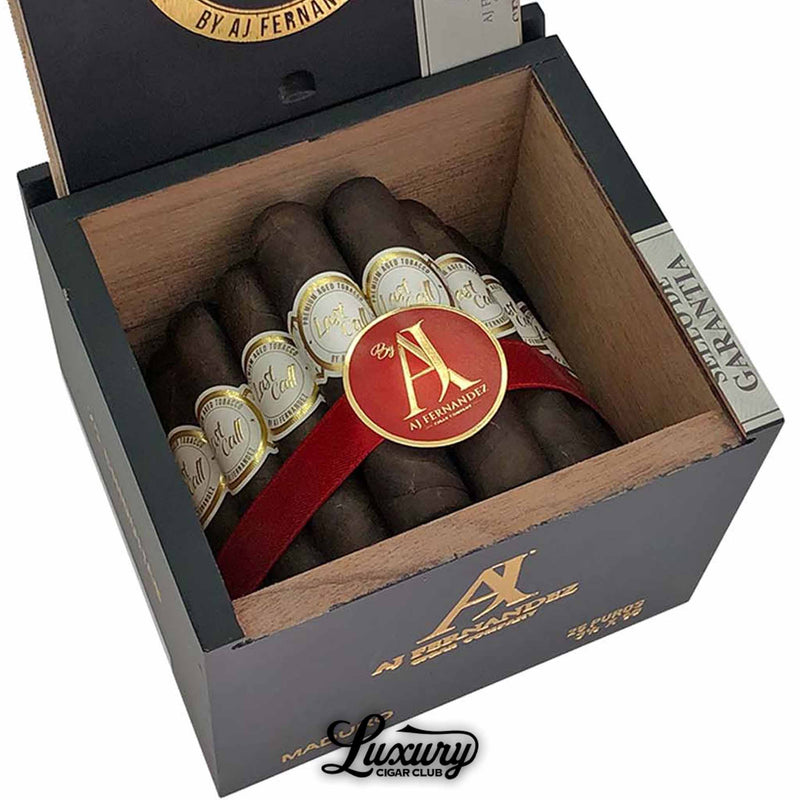 Close up product image of AJ Fernandez Last Call Maduro Chiquitas cigars from Luxury Cigar Club, featuring dark maduro short cigars bundled tightly with a red ribbon, highlighting the gold AJ Fernandez badge and detailed cigar bands.