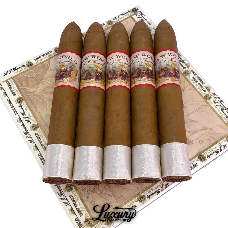 AJ Fernandez New World Connecticut Belicoso cigars resting on the box lid with pointed caps and intricate artwork bands, presented by Luxury Cigar Club.