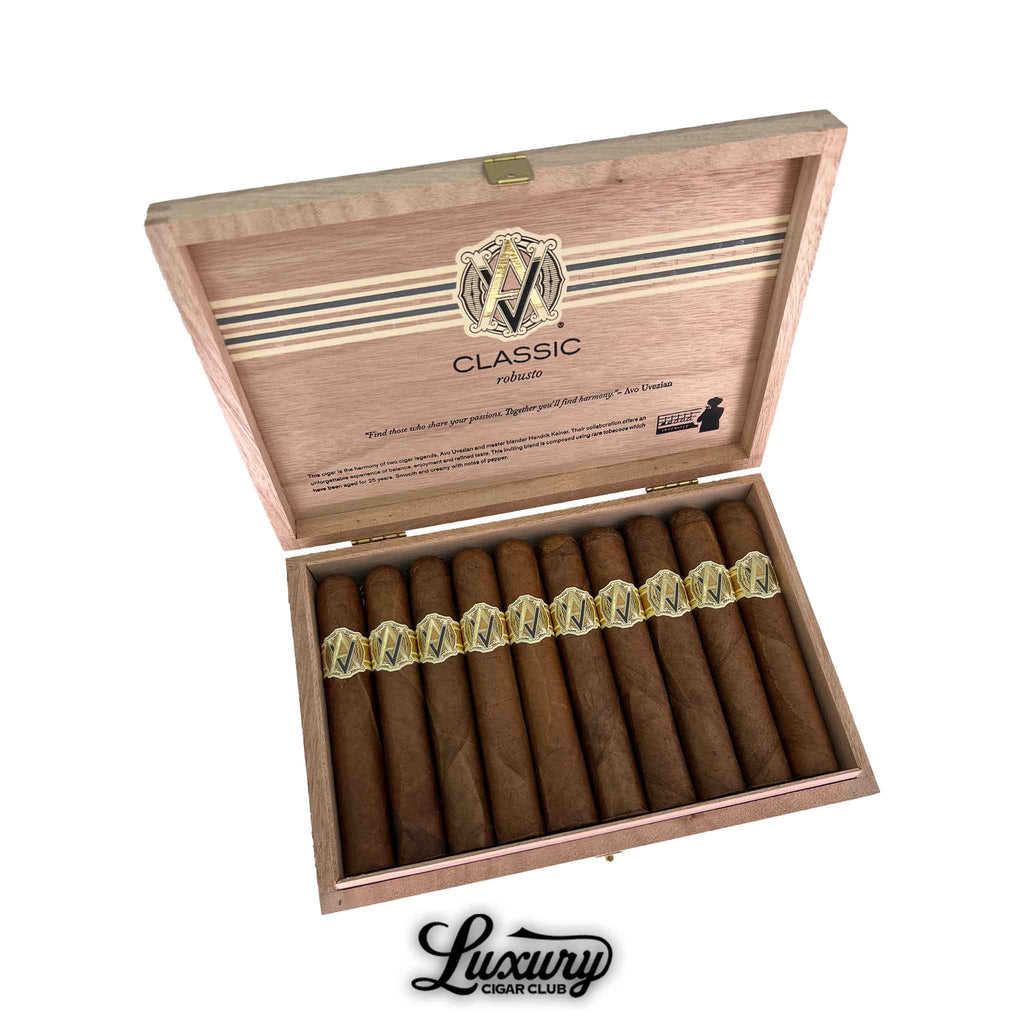 Open box of AVO Classic Robusto cigars showcasing a row of golden-brown cigars with elegant gold and cream AVO bands. The inside lid features the AVO logo and “Classic Robusto” branding. Luxury Cigar Club logo displayed below.