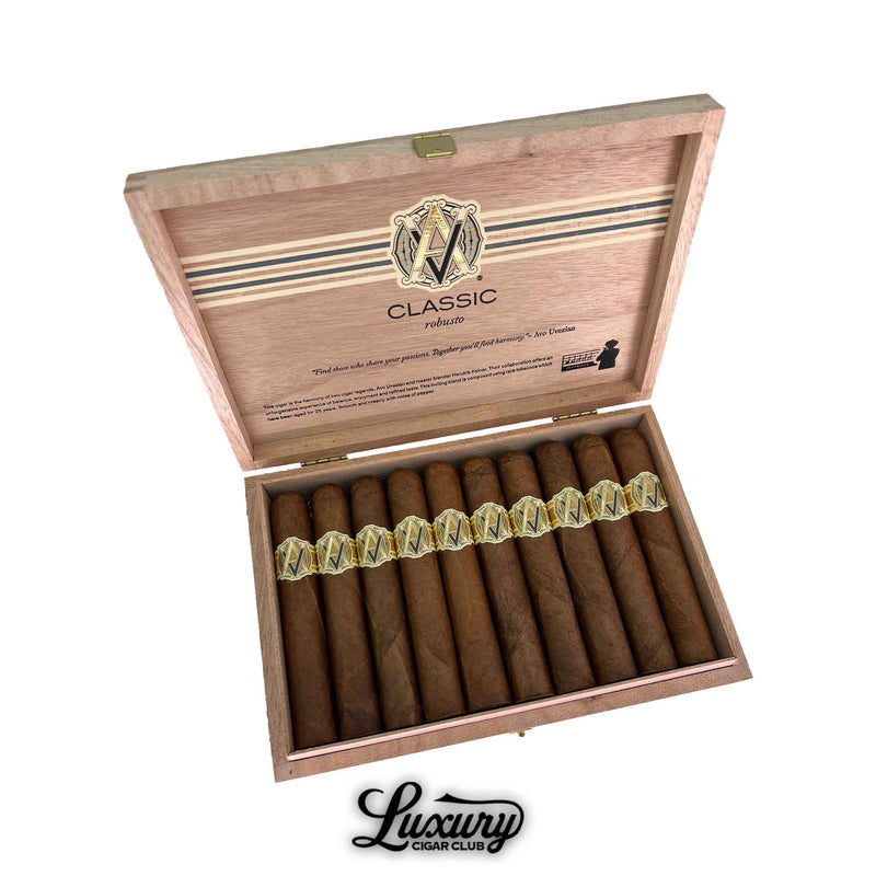 Open box of AVO Classic Robusto cigars showcasing a row of golden-brown cigars with elegant gold and cream AVO bands. The inside lid features the AVO logo and “Classic Robusto” branding. Luxury Cigar Club logo displayed below.