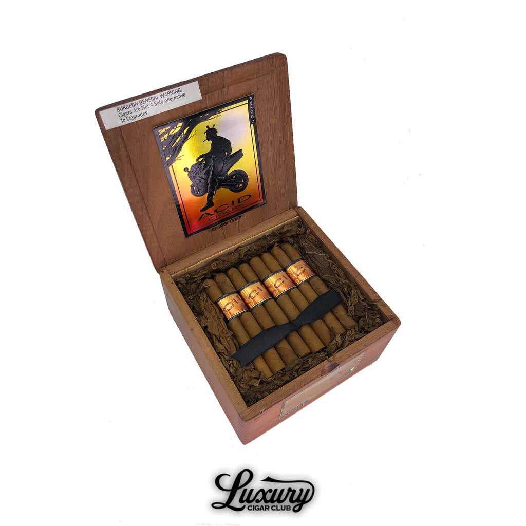 Open box of Acid Subcultures Amigos cigars by Drew Estate with decorative lid artwork and Luxury Cigar Club branding.