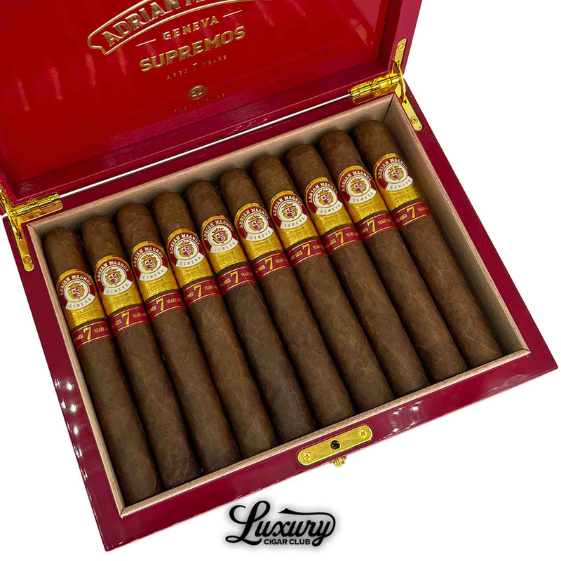 Close-up of Adrian Magnus Supremos Toro cigars, highlighting golden and red cigar bands inside an elegant red humidor box – Luxury Cigar Club exclusive.