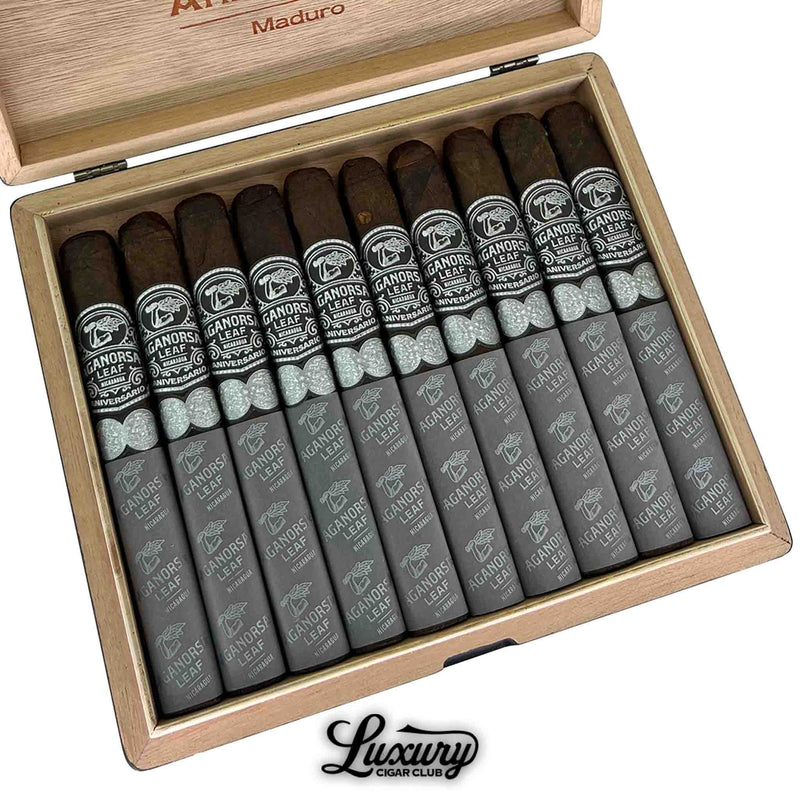 Close-up of a box of Aganorsa Leaf Aniversario Maduro Toro cigars, featuring dark Nicaraguan wrappers and elegant black and silver bands, neatly arranged inside a wooden box marked “Maduro” on the lid.