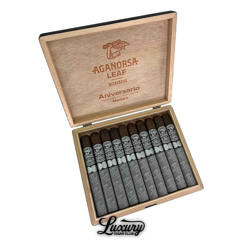 Box of Aganorsa Leaf Aniversario Maduro Toro cigars, elegantly displayed with dark brown wrappers and black-and-silver bands, set in a wooden box labeled "Aniversario Maduro" with the Aganorsa Leaf logo on the lid.