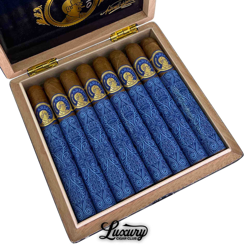 Close-up view of Aganorsa Leaf Arsenio Toro cigars inside an open box, showcasing blue patterned tissue wraps and blue-and-gold bands featuring Arsenio’s portrait. Luxury Cigar Club branding is visible below the box.