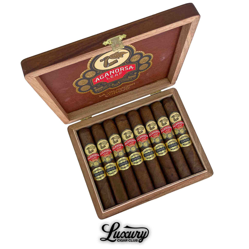 Aganorsa Leaf La Validacion Corojo Gran Robusto cigars displayed in an open wooden box with the Aganorsa Leaf logo on the lid, showcasing eight premium cigars with gold and red bands, available at Luxury Cigar Club.