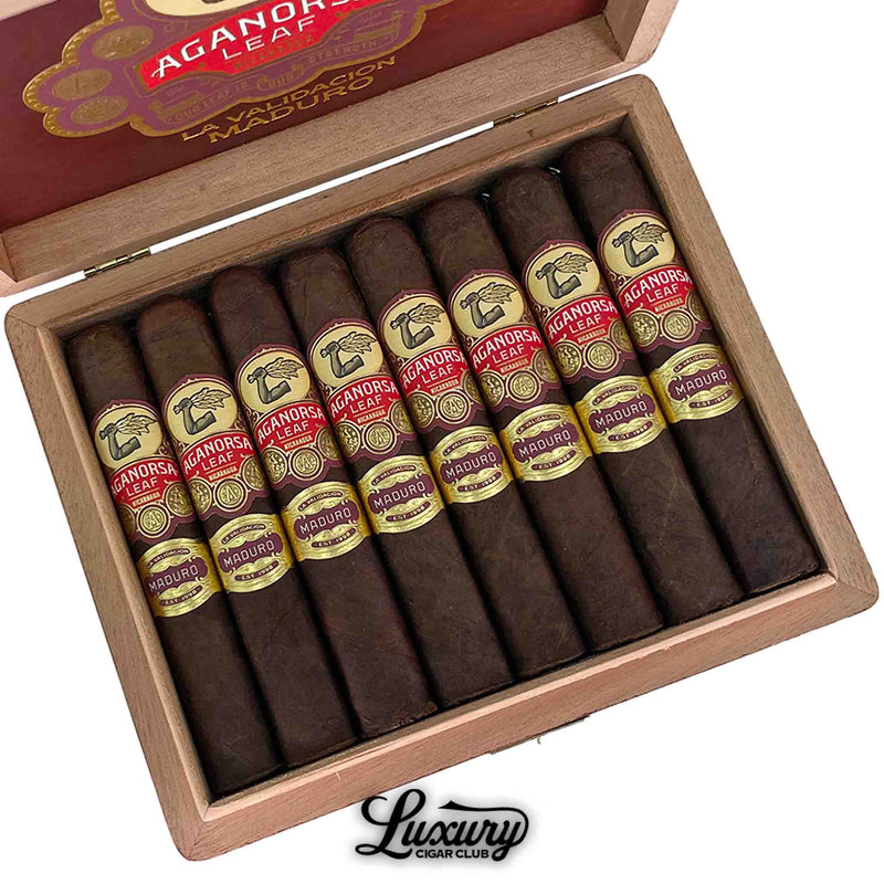  Close-up image of Aganorsa Leaf La Validacion Maduro Gran Robusto cigars in a wooden box, showcasing the dark maduro wrappers and detailed red and gold cigar bands, Luxury Cigar Club premium selection.