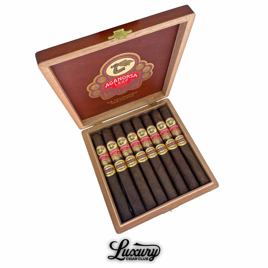 Open box of Aganorsa Leaf La Validacion Maduro Toro cigars with dark maduro wrappers and red-gold bands, premium handmade cigars displayed by Luxury Cigar Club.