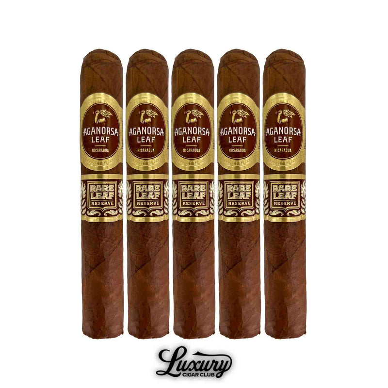 Five Aganorsa Leaf Rare Leaf Reserve Corojo Robusto cigars lined up with deep brown wrappers, highlighted by elegant dual gold and maroon bands. Nicaraguan blend displayed for Luxury Cigar Club.