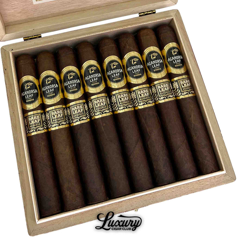Close-up of Aganorsa Leaf Rare Leaf Reserve Maduro Toro cigars arranged neatly inside a cedar box, highlighting the rich Maduro wrapper and ornate black-and-gold double bands. Luxury Cigar Club.