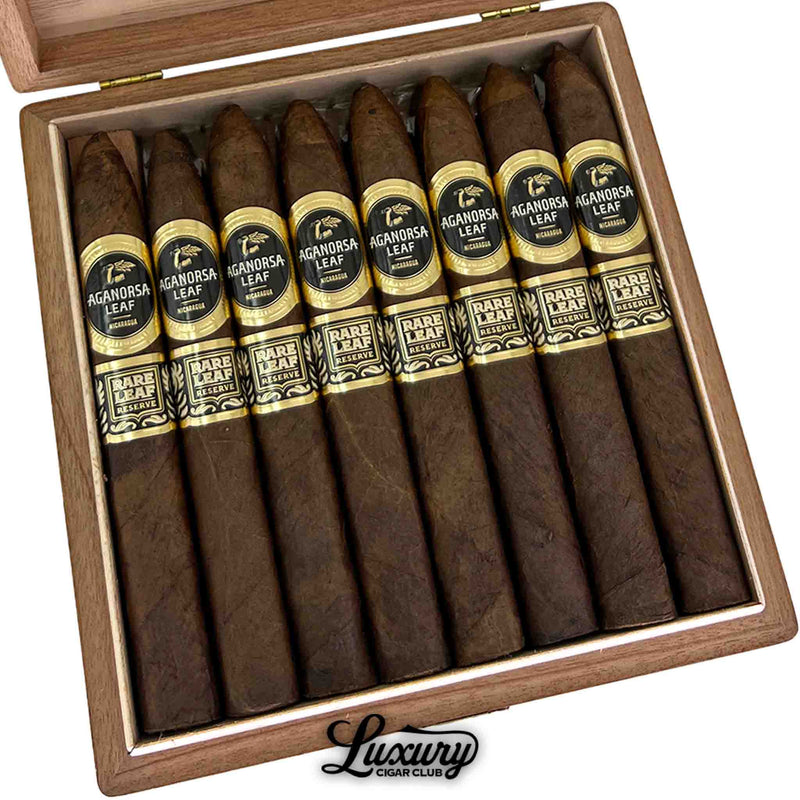 Close-up of Aganorsa Leaf Rare Leaf Reserve Maduro Torpedo cigars in their box, highlighting the dark Maduro wrapper and elegant gold-accented black labels reading “Rare Leaf Reserve.” Luxury Cigar Club branding.