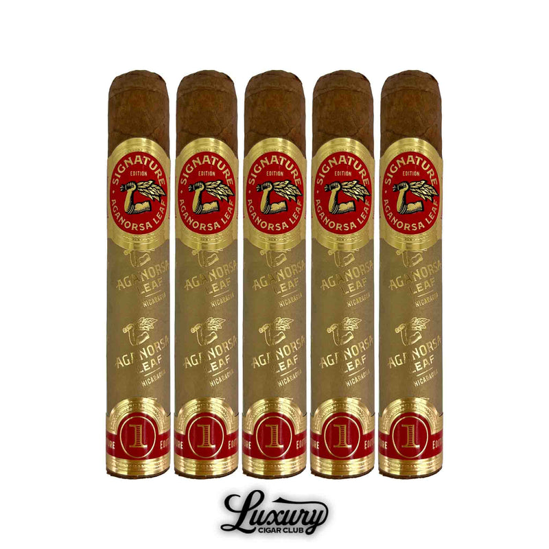 Five Aganorsa Leaf Signature Selection Robusto cigars displayed upright, wrapped in light golden sleeves with red and gold “Signature Edition” bands featuring the Aganorsa Leaf logo. Luxury Cigar Club branding below.
