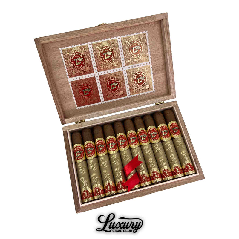 Open box of Aganorsa Leaf Signature Selection Robusto cigars wrapped in gold foil with red bands and decorative inner lid, from Luxury Cigar Club.