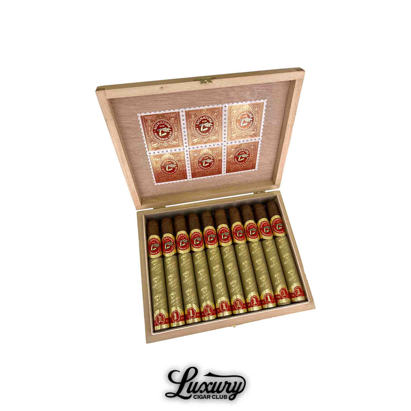 Open wooden box of Aganorsa Leaf Signature Selection Toro cigars, each dressed in gold foil sleeves and red-and-gold bands. The box lid features decorative Aganorsa Leaf stamp designs. Luxury Cigar Club branding beneath.