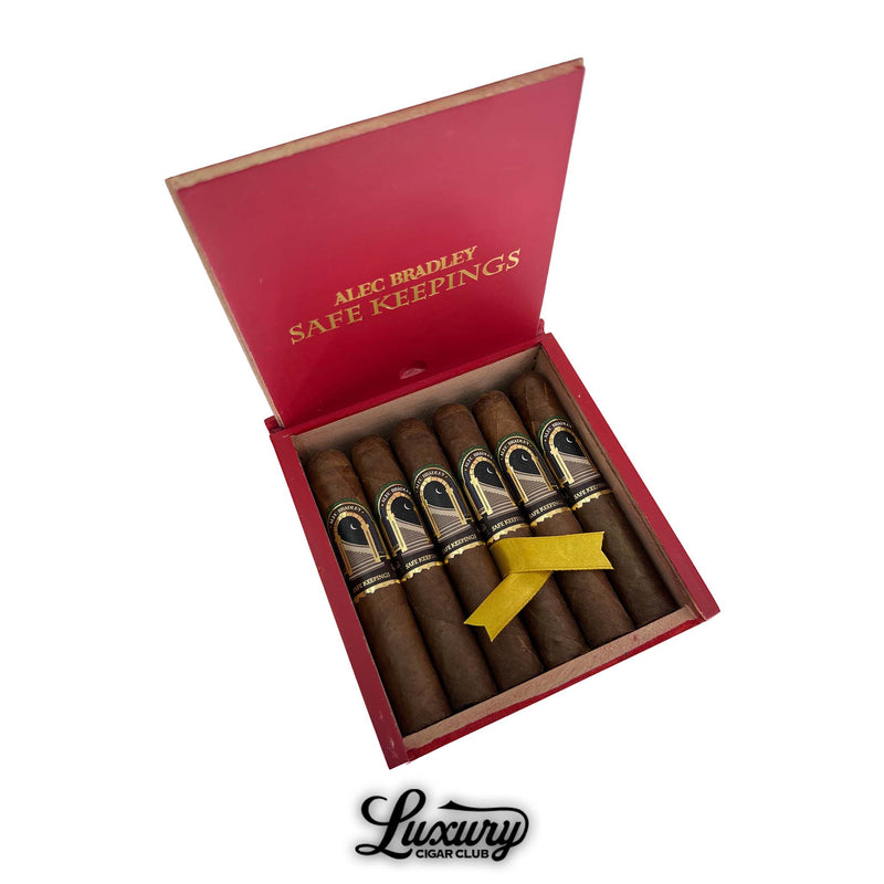 Open box of Alec Bradley Safe Keepings Robusto cigars featuring dark brown cigars with black and gold bands, neatly arranged in a red box with gold lettering — available at Luxury Cigar Club.
