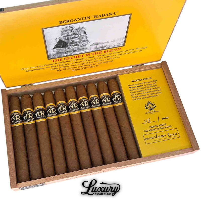 Close-up of Altezas Reales 1871 Corona cigars showing detailed cigar bands, tribute information, and bright yellow packaging insert, exclusive to Luxury Cigar Club.