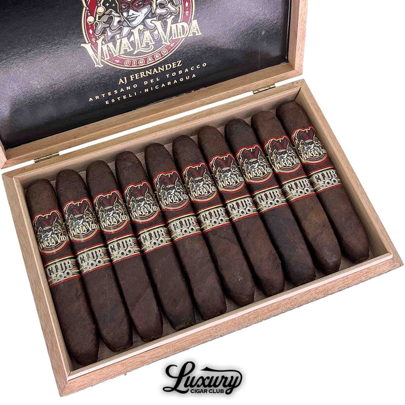 Close-up view of Artesano Del Tobacco Viva La Vida 5th Anniversary Club 500 Sabroso cigars, featuring bold jester artwork and "Club 500" secondary bands in a traditional wooden box handcrafted by AJ Fernandez in Estelí, Nicaragua.