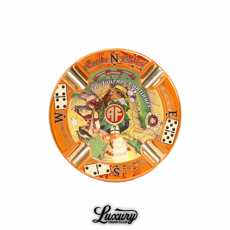 Arturo Fuente Casa Cuba limited edition porcelain ashtray featuring a vibrant orange rim, gold cigar rests, compass markings, domino illustrations, and central artwork with "The Journey Continues" text and AF logo.