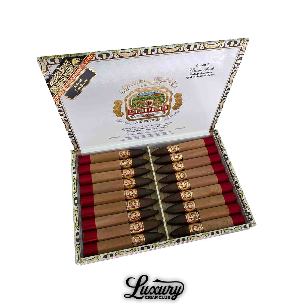 Open box of Arturo Fuente Chateau Fuente Queen B cigars, featuring dark Ecuadorian Sun Grown wrappers, cedar sleeves, and red foot bands, arranged in ornate packaging with Luxury Cigar Club branding below.