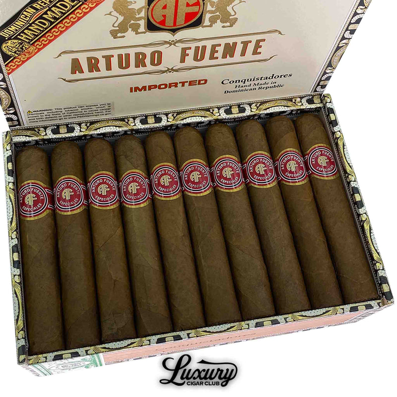 Close-up view of Arturo Fuente Especiales Conquistadores Natural cigars neatly arranged in an open box, showing red and white branded cigar bands and ornate packaging details.
