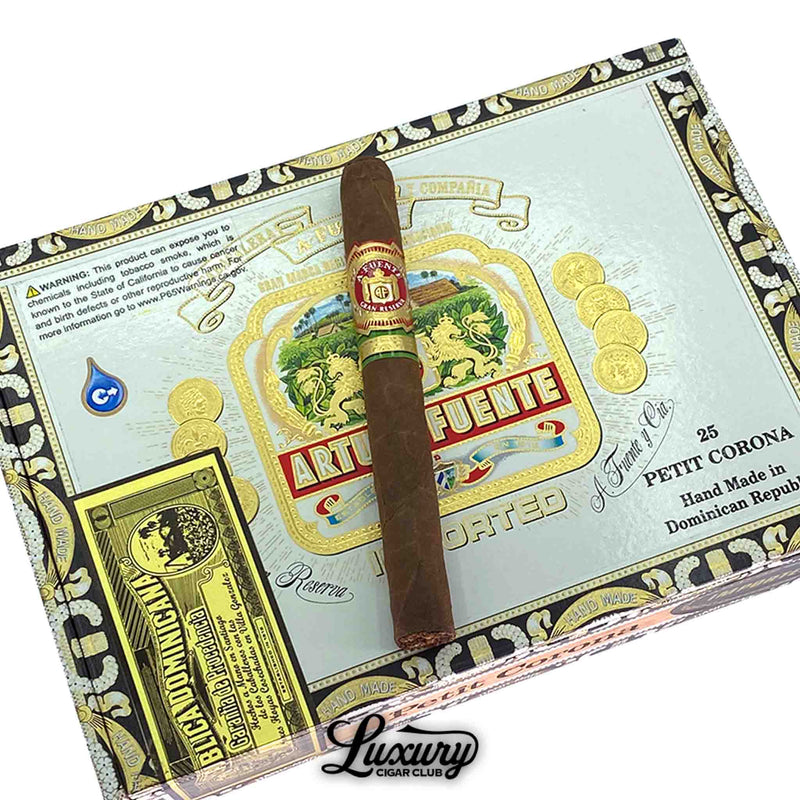 Close-up of Arturo Fuente Gran Reserva Petit Corona Natural cigar resting on branded box - Luxury Cigar Club