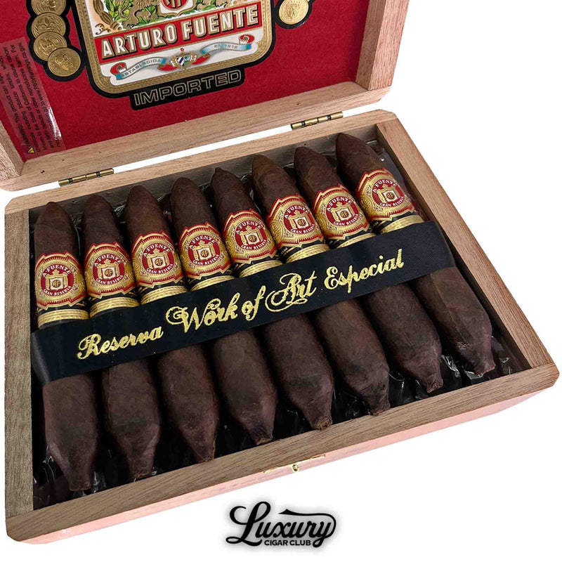 Close-up of Arturo Fuente Hemingway Maduro Work of Art Especial cigars in box, showcasing detailed cigar bands, dark maduro wrappers, and elegant black and gold “Reserva Work of Art Especial” ribbon — Luxury Cigar Club.