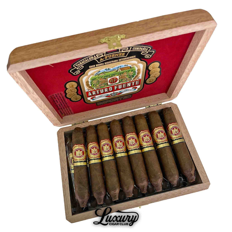 Open wooden box of Arturo Fuente Hemingway Natural Best Seller Cigars, featuring 8 cigars with signature perfecto shapes and classic red, gold, and cream bands. The box interior lid is lined with red velvet and displays the ornate Arturo Fuente logo. The Luxury Cigar Club logo is shown below.