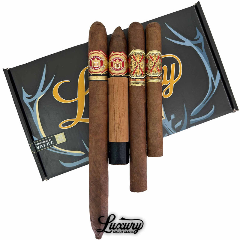Close-up of Arturo Fuente Opus X 7th Anniversary Sampler cigars with detailed bands and wrappers on Luxury Cigar Club box.