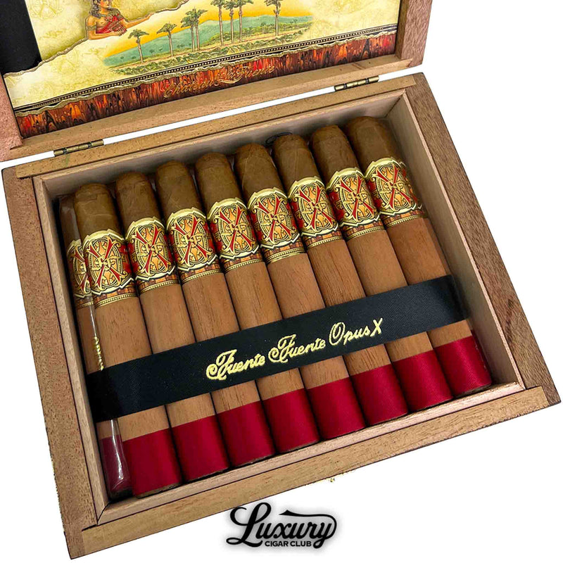 Close-up angled view of Arturo Fuente Opus X Limited Edition Double Robusto cigars in their wooden box, showing cedar sleeves, red foot bands, and gold/red bands, secured with a black ribbon.