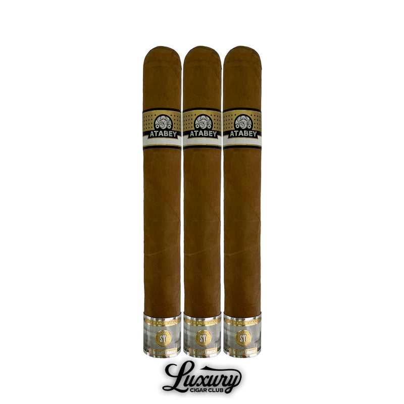 Trio of Atabey Benditos cigars with elongated format, light brown wrapper, black and gold Atabey logo bands, golden decorative foot details, arranged vertically with Luxury Cigar Club logo underneath.