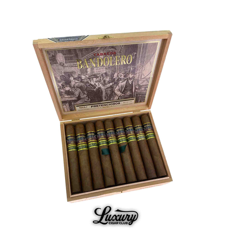 Open box of Bandolero Serie T Pretenciosos cigars, showing 25 premium long-filler cigars with brown wrappers and green ribbon accents, displayed by Luxury Cigar Club.