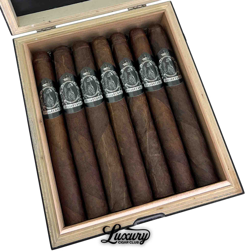Close up view of Black Label Trading Co. Deliverance Nocturne Toro cigars lined inside the wooden box, highlighting the dark oily wrapper texture and detailed silver Deliverance band artwork, presented by Luxury Cigar Club.