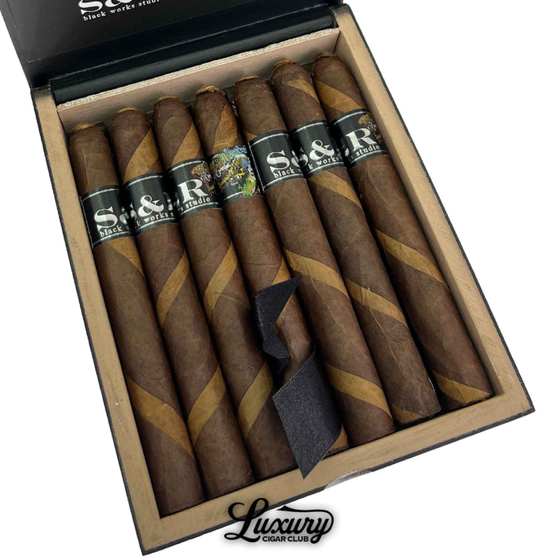 Close-up of Black Works Studio S&R Limited Edition Corona Larga cigars featuring barber pole wrappers with dark and light contrasts, available from Luxury Cigar Club.