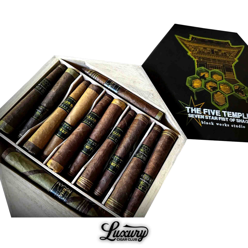 Black Works Studio The Five Temples Seven Star Fist of Shaolin limited edition 12-pack box open to display assorted cigars with dark and barber-pole wrappers, featuring black and gold bands, presented by Luxury Cigar Club.
