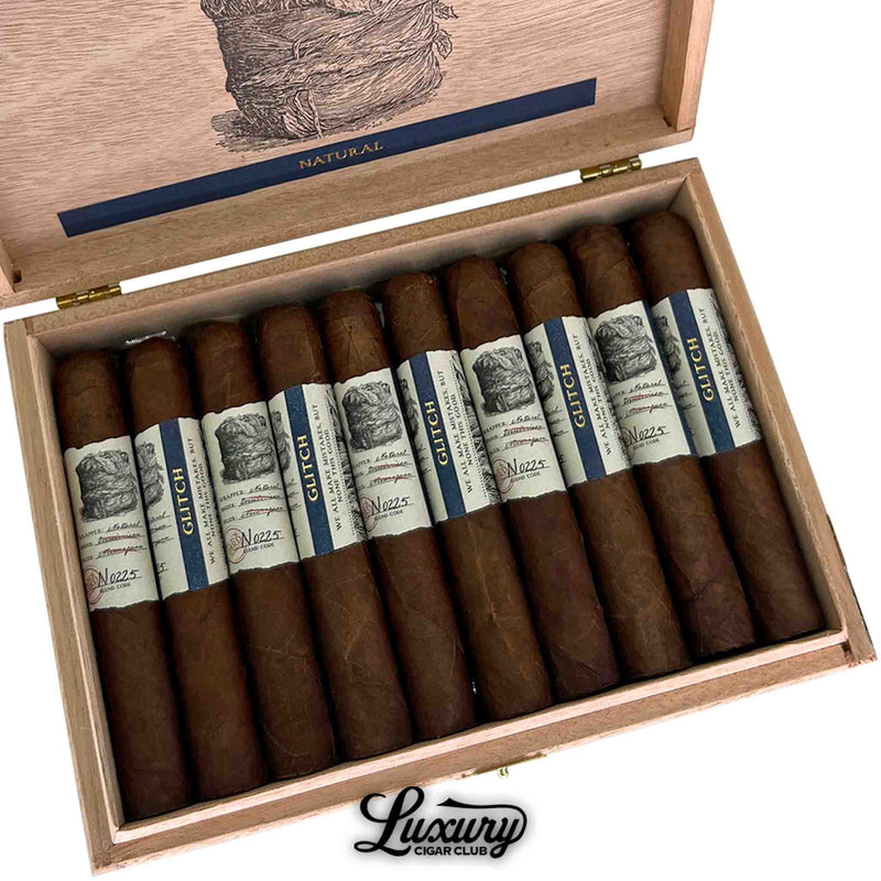Close-up of the Blackbird Glitch Natural Robusto cigar box showing rich brown wrappers and blue-cream bands with “Glitch” branding, offered by Luxury Cigar Club.