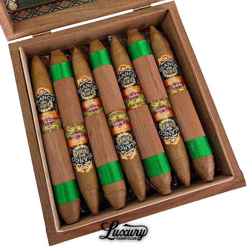 Close-up view of Blanco Liga Exclusiva de Familia Connecticut Salomon cigars neatly arranged in a wooden box, featuring dual bands and green ribbon foot bands with detailed label artwork. Luxury Cigar Club logo visible.