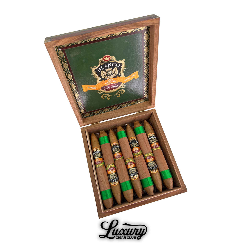 Open wooden box of Blanco Liga Exclusiva de Familia Connecticut Salomon cigars with elegant green and gold interior lid design and cigars wrapped with green ribbon accents. Luxury Cigar Club logo shown below.