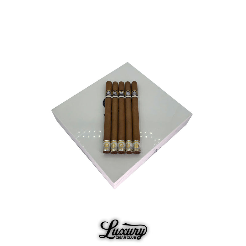 Open box of Atabey Spiritus cigars from Luxury Cigar Club, featuring five elegant, long cigars with golden and black bands displayed on a glossy white lacquered box