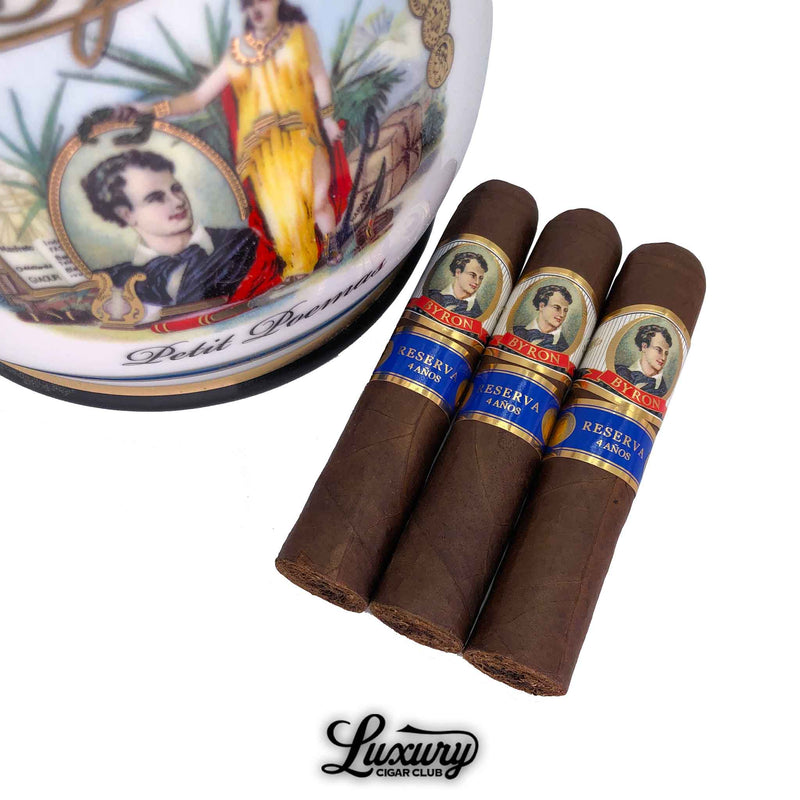 Close up of Byron 19th Century Petit Poemas cigars with Reserva 4 Años blue and gold bands next to decorative jar, Luxury Cigar Club
