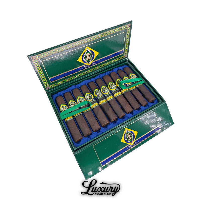 Open box of CAO Brazilia Box-Pressed robusto cigars in vibrant green packaging, displaying twelve dark-wrapped cigars with bold yellow, blue, and green bands; presented by Luxury Cigar Club.