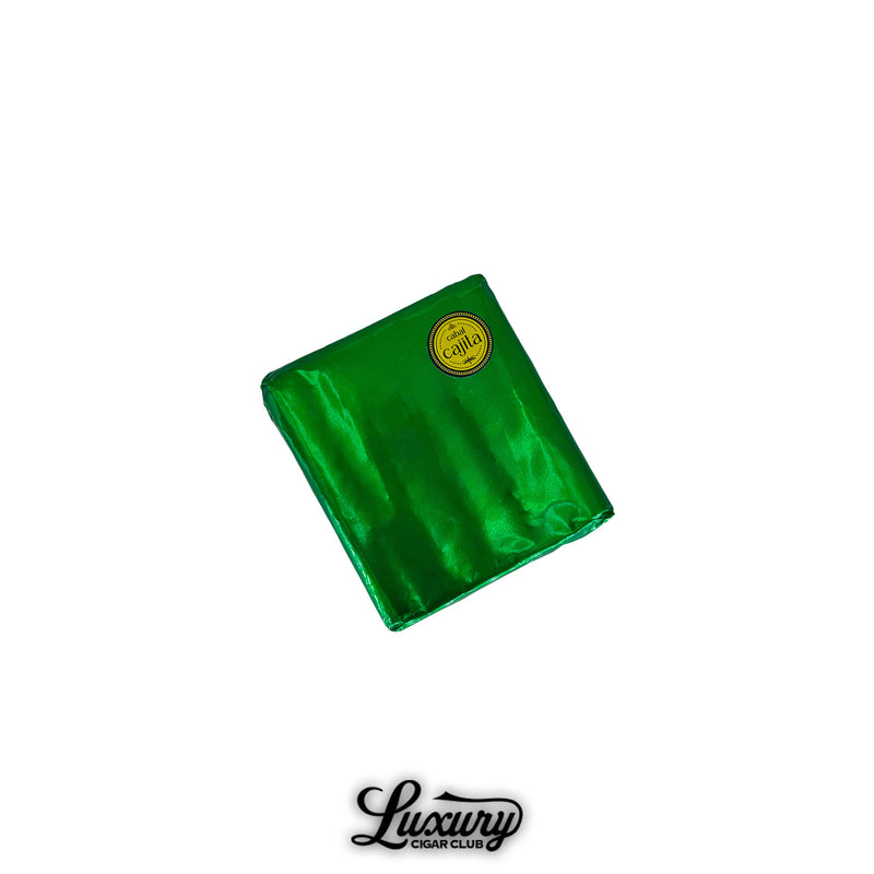 Cabal Cajita 10th Anniversary Petite Robusto cigar wrapped in metallic green foil with a gold and black circular label, displayed above the Luxury Cigar Club logo.