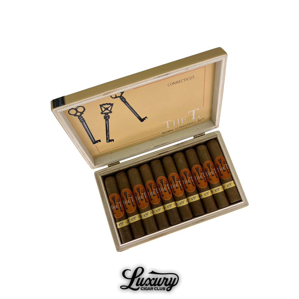 Open box of Caldwell The T Connecticut Robusto Minor cigars with golden brown wrappers, orange and gold bands, and key design inside lid, Luxury Cigar Club logo