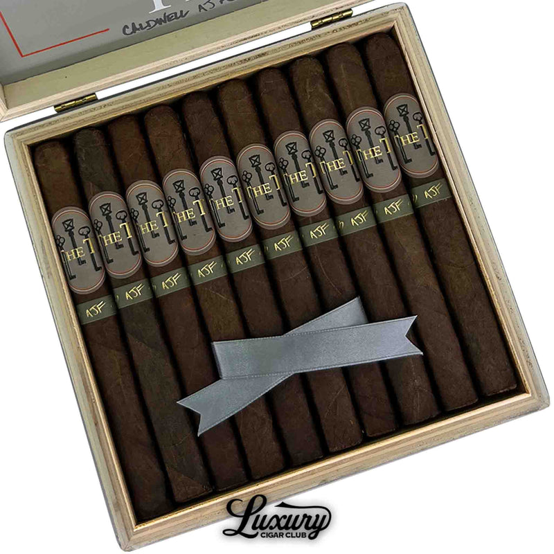 Close-up of Caldwell The T Lonsdale cigars inside the box with detailed view of dark wrappers and gold-accented bands.
