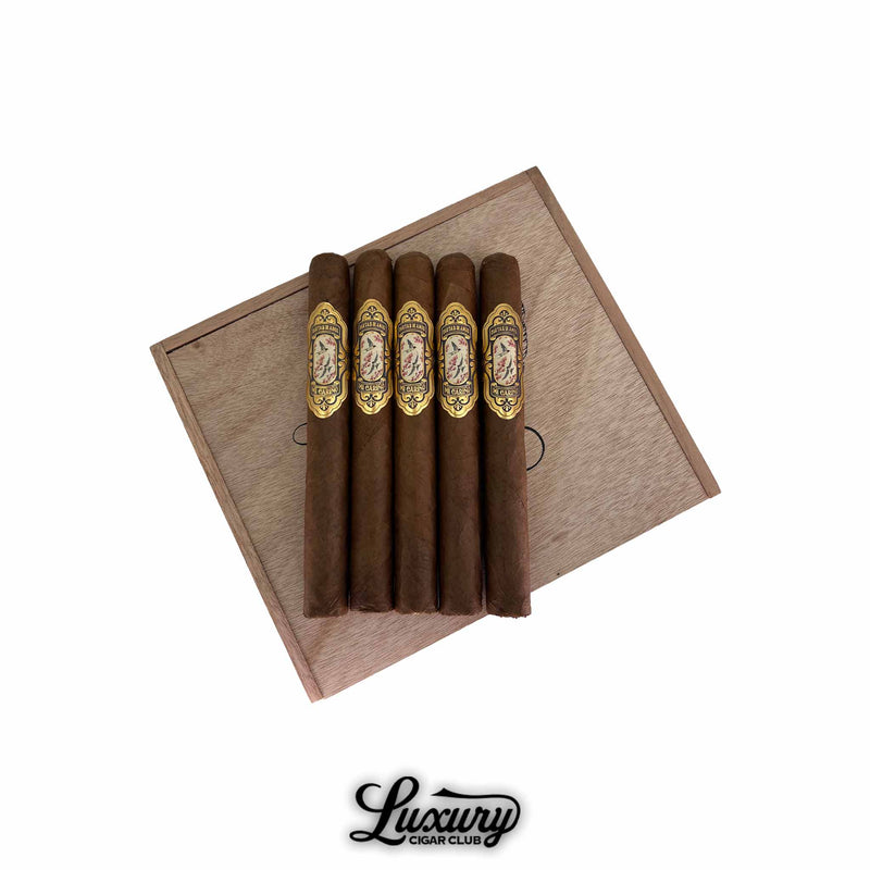 Cartas de Amor Mi Cariño Corona Gorda 5-pack cigars arranged on a wooden box lid, featuring ornate gold and floral bands, available at Luxury Cigar Club.