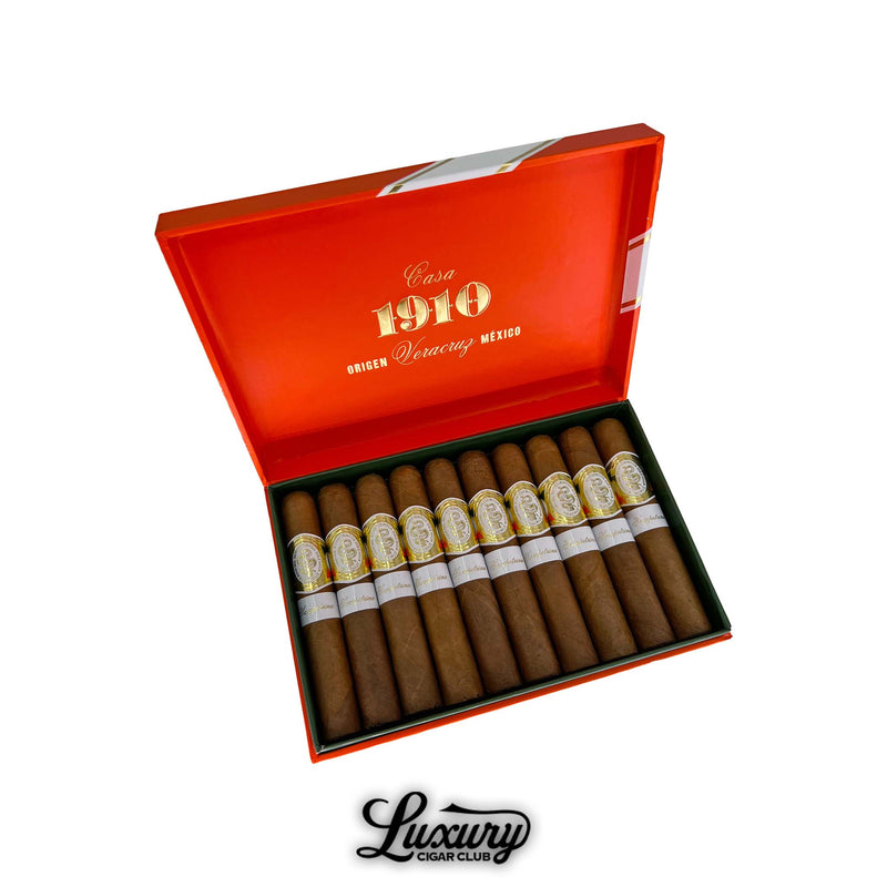 Open orange box of Casa 1910 Soldadera Edition Sampetrina cigars featuring ten premium cigars with gold and white bands neatly aligned inside. Luxury Cigar Club logo below.