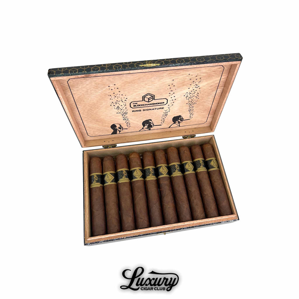 Open wooden box of Casdagli The Blockchain Smokers Wide Churchill cigars from Luxury Cigar Club, showing ten wide Churchill vitolas with reddish-brown wrappers and black-and-gold hexagonal cigar bands, with interior lid artwork depicting silhouetted smokers and ring-signature branding.