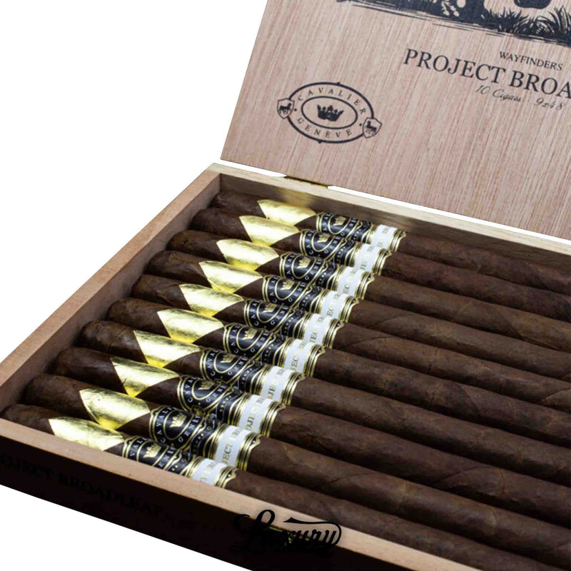 Open box of Cavalier Genève Project Broadleaf Wayfinders A cigars showing gold-foil tips and elegant branding, offered by Luxury Cigar Club.
